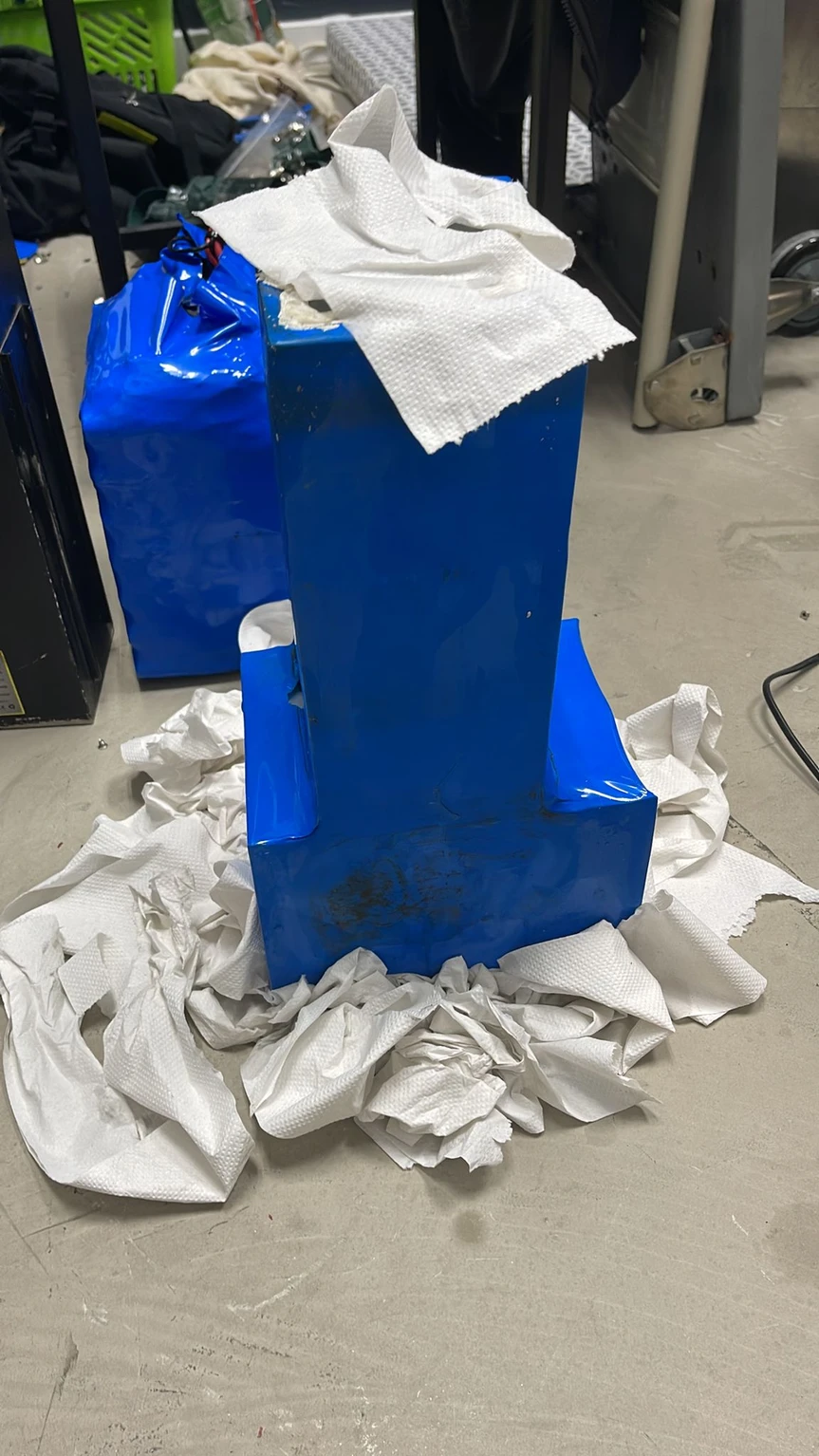 Creased blue wrapping around a tall pack, with loose covering at the top.