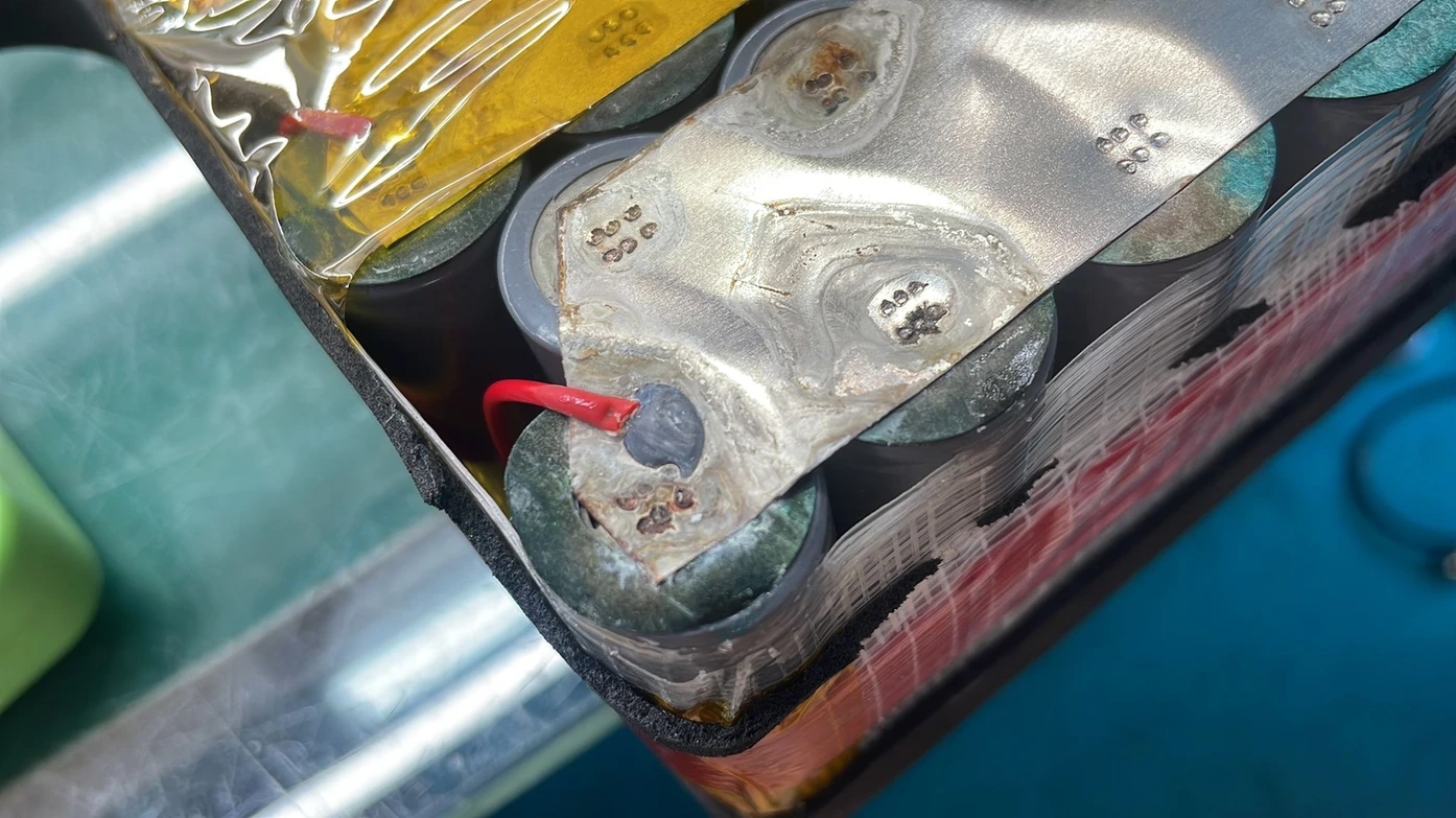 Rough, blistered-looking metal strip and wire on the cells of an opened pack.