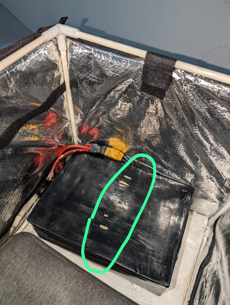 An old black pack in a lined bag, with marks on its case circled.