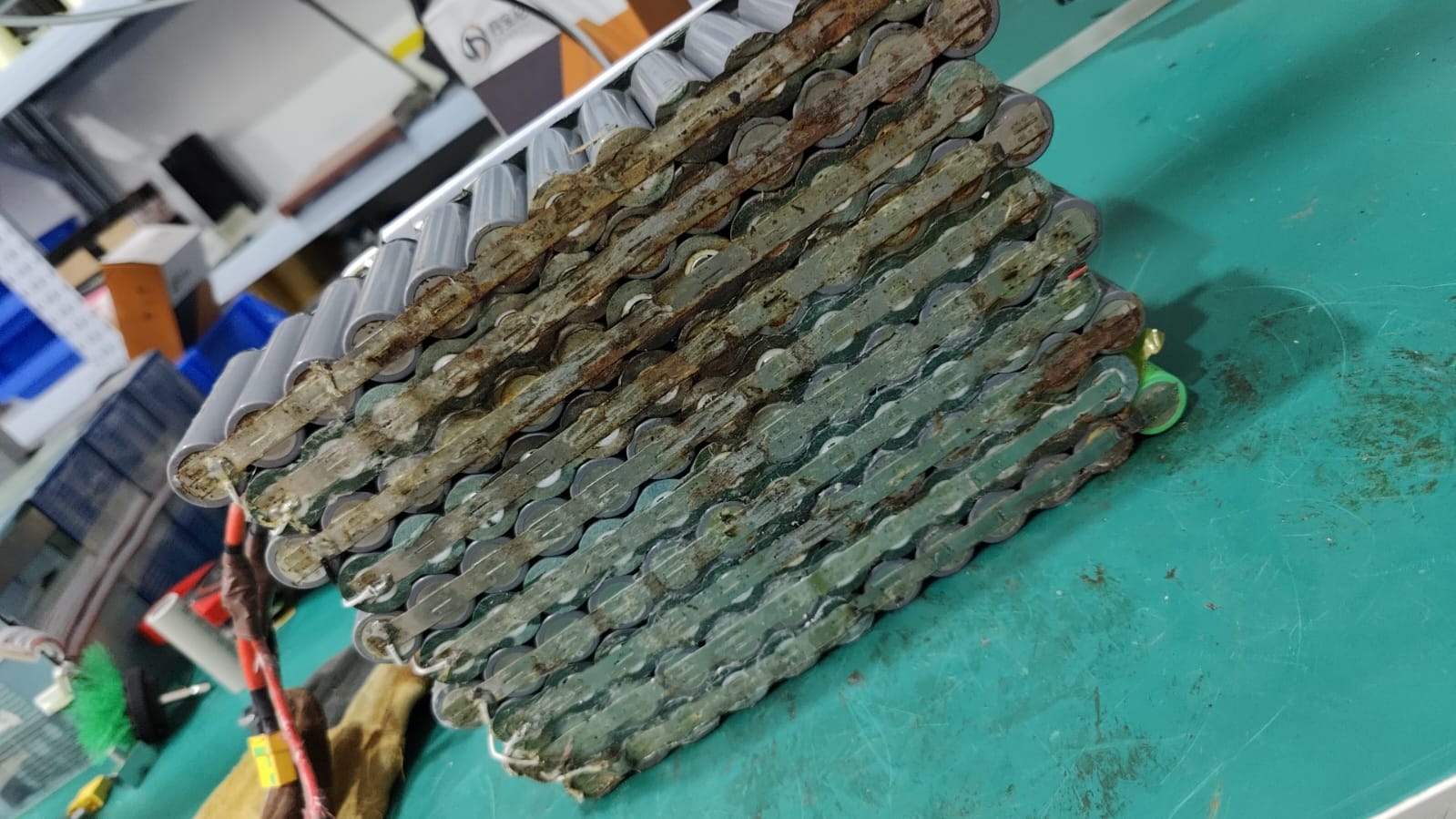 Green and brown deposits across metal links on an opened assembly.
