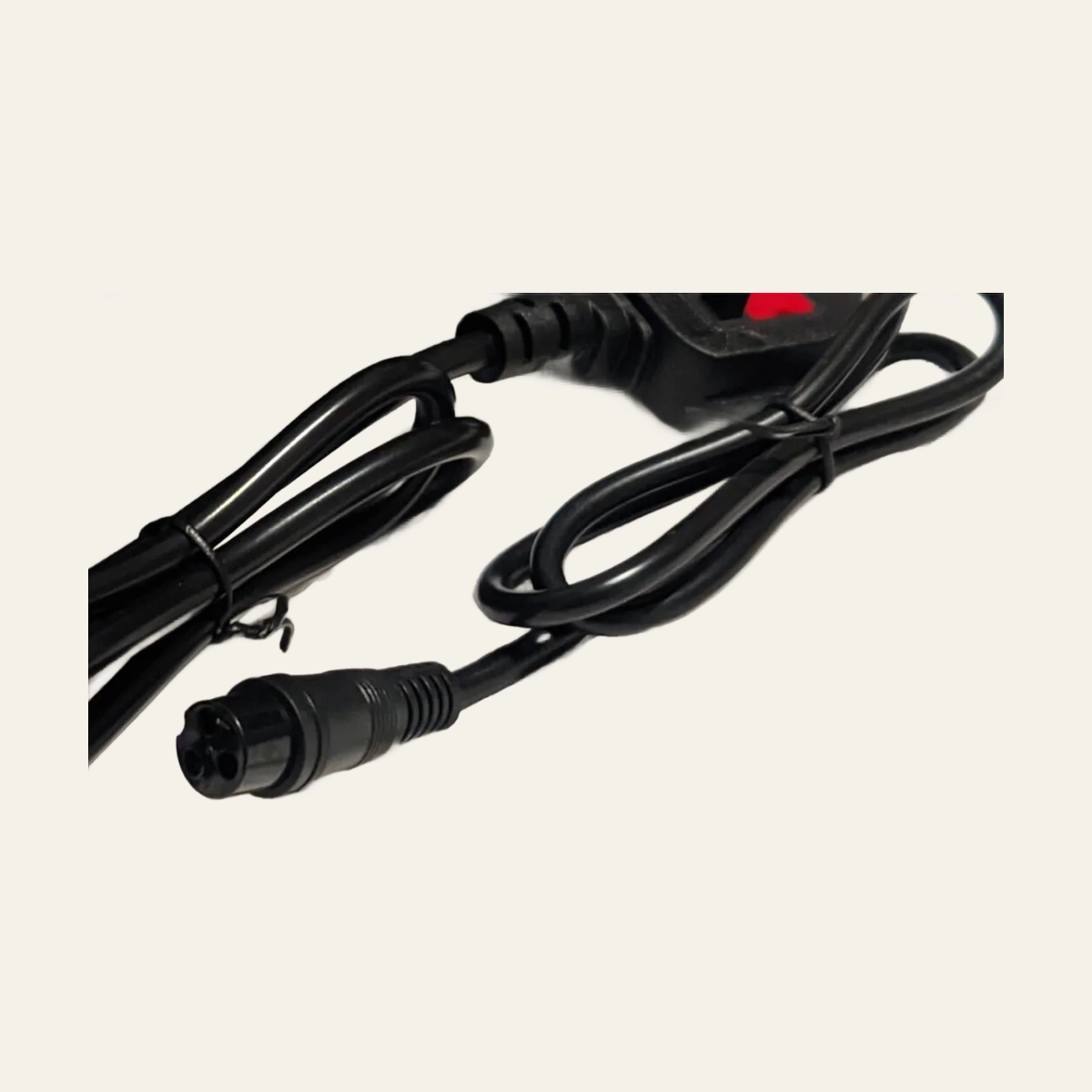 Close view of charger cable and round three-pin connector