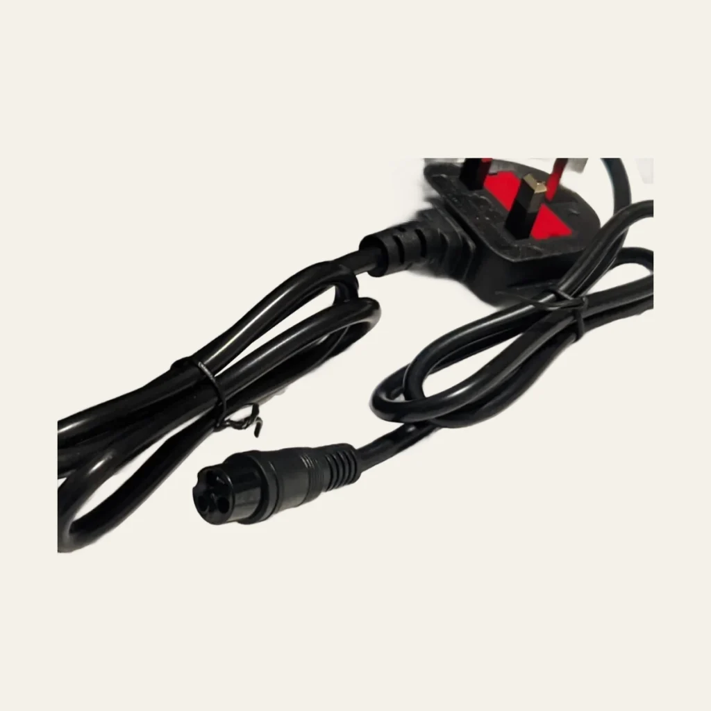 Close view of charger cable and round three-pin connector