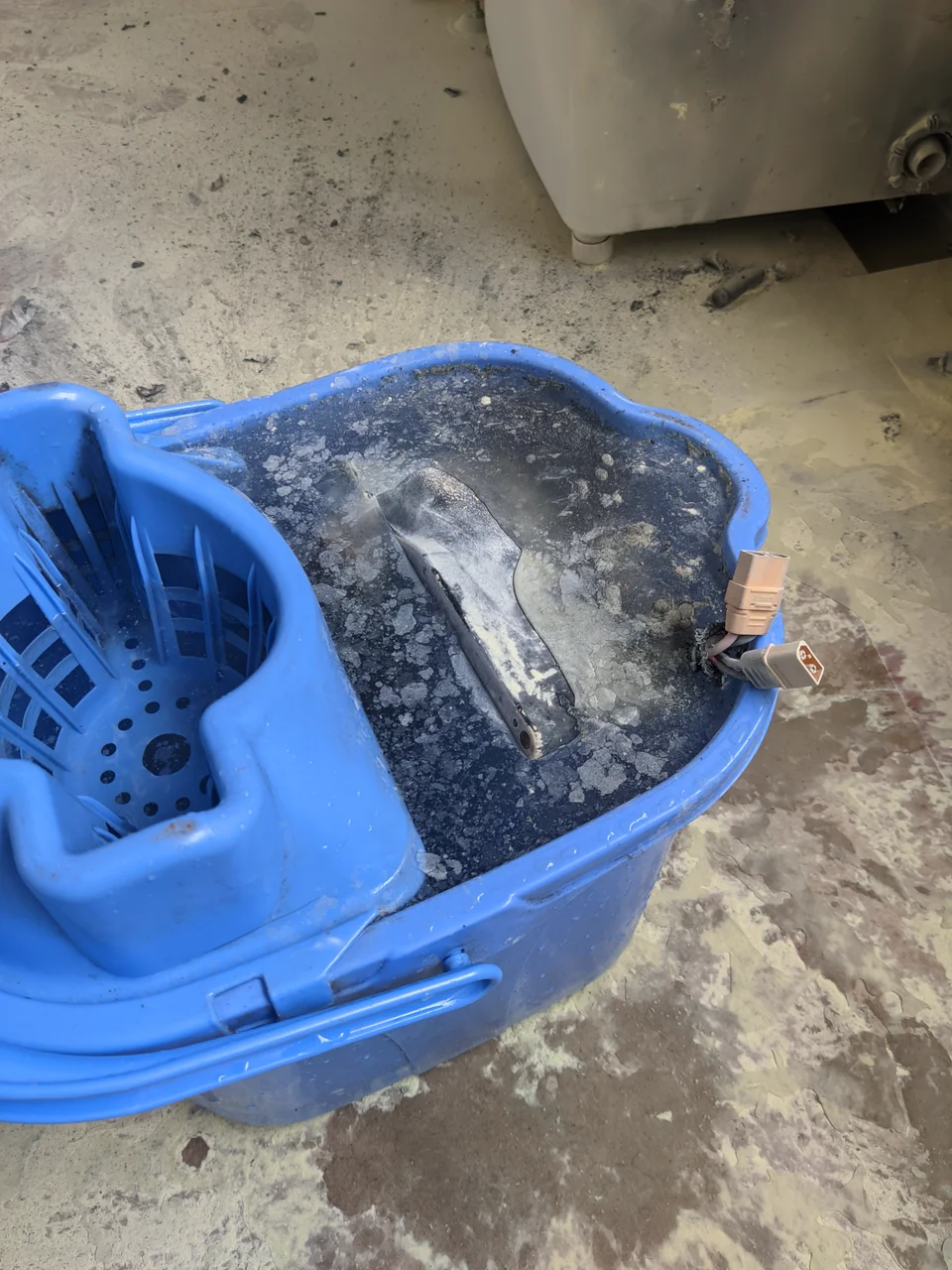 Close-up of the burnt battery pack in the bucket of water