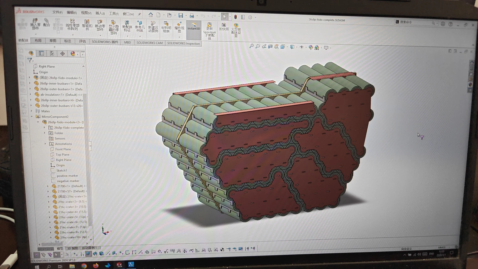 A laptop screen showing a battery pack assembly model in SolidWorks.
