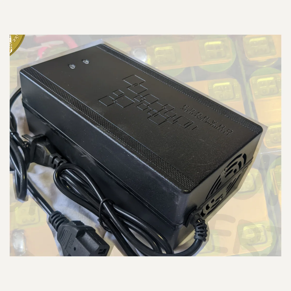 A black charger with cables and a rectangular connector.