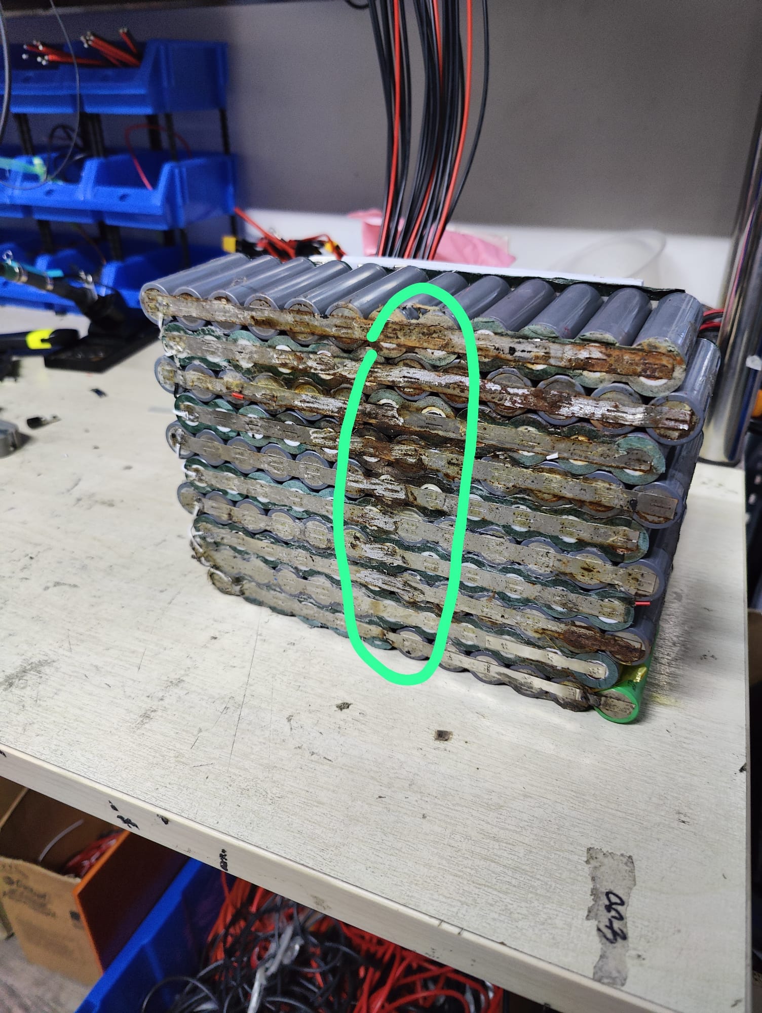 Corroded lithium battery interconnect strips across multiple cell groups