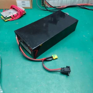 Example low flat black rectangular battery pack with an XT90-type plug and separate charging lead on a bench.