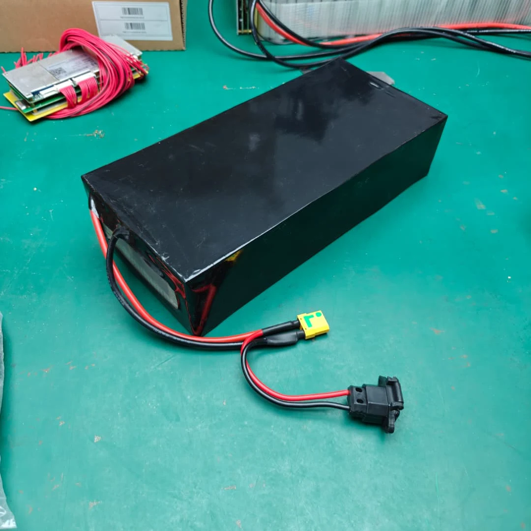 Example low flat black rectangular battery pack with an XT90-type plug and separate charging lead on a bench.