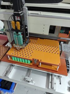 Automated spot-welding machine assembling a dogeTune lithium battery pack
