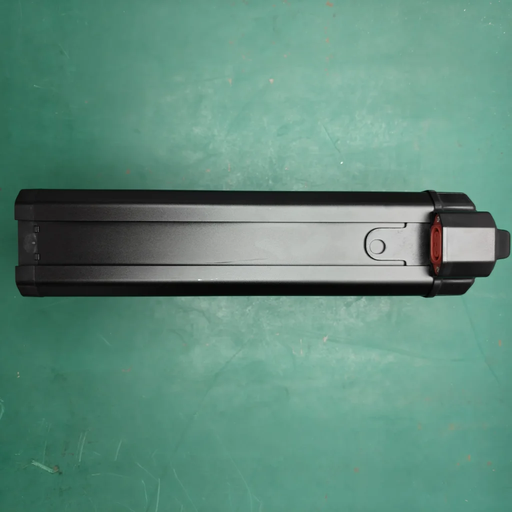 Underside of a battery case showing its mounting rail and red connector