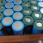 Green insulation rings around the raised cell terminals, with black holder walls between the cells.