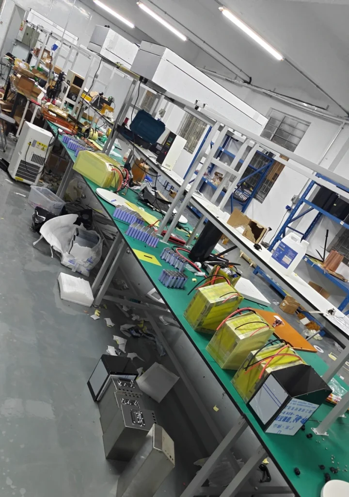Workbench line with rows of purple cells and several Razor packs wrapped in FR-4 beside their cases