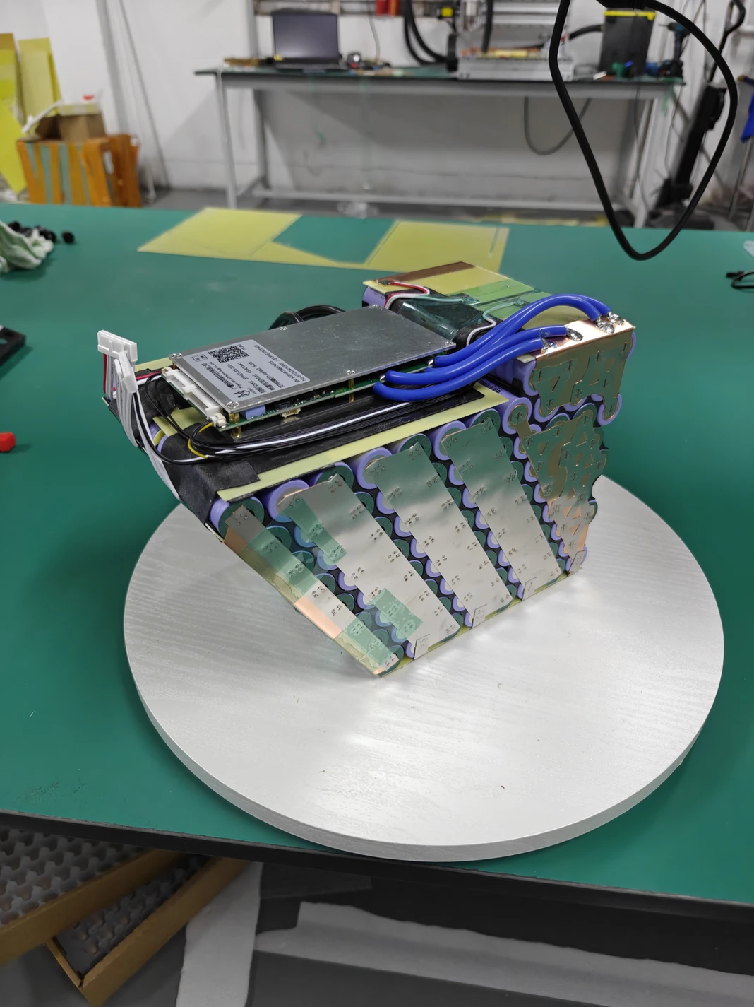 Open Razor battery assembly with visible cell connections, a circuit board and blue wiring.