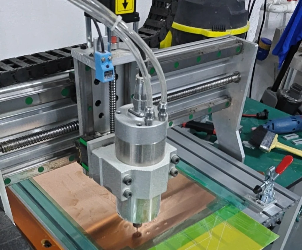 CNC spindle over a copper sheet on the cutting bed