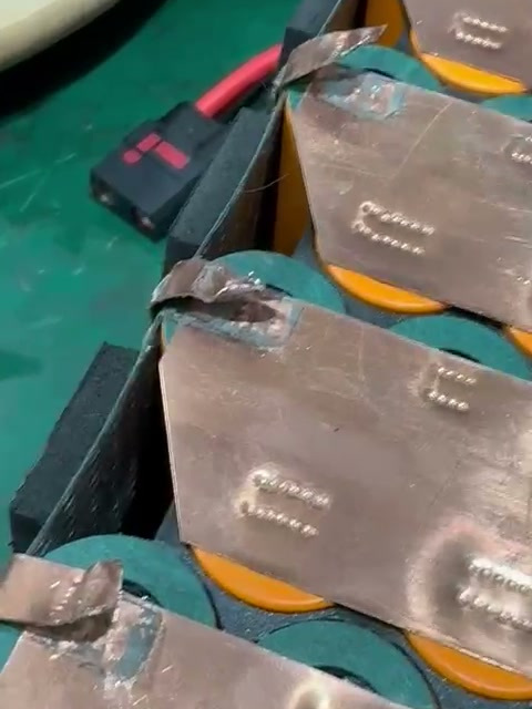 Incoming pack: a copper tab raised above a cell end.