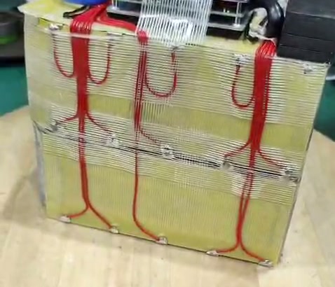 Red wires loop across the yellow-covered pack beneath bands of clear tape.