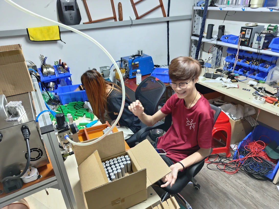 Team members at the Primz Bizhub battery workbench, with cells, tools and equipment.