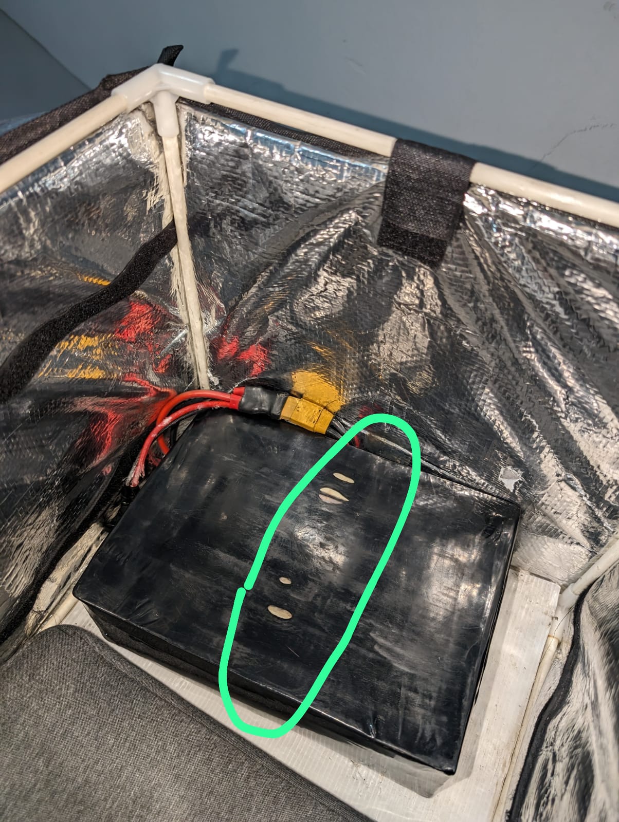 Outer casing of a used e-bike battery showing visible abrasion and heat-damaged spots