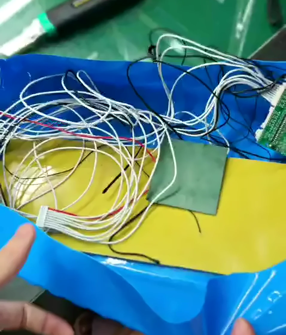 A tangle of thin white balance wires lying on the Kapton tape