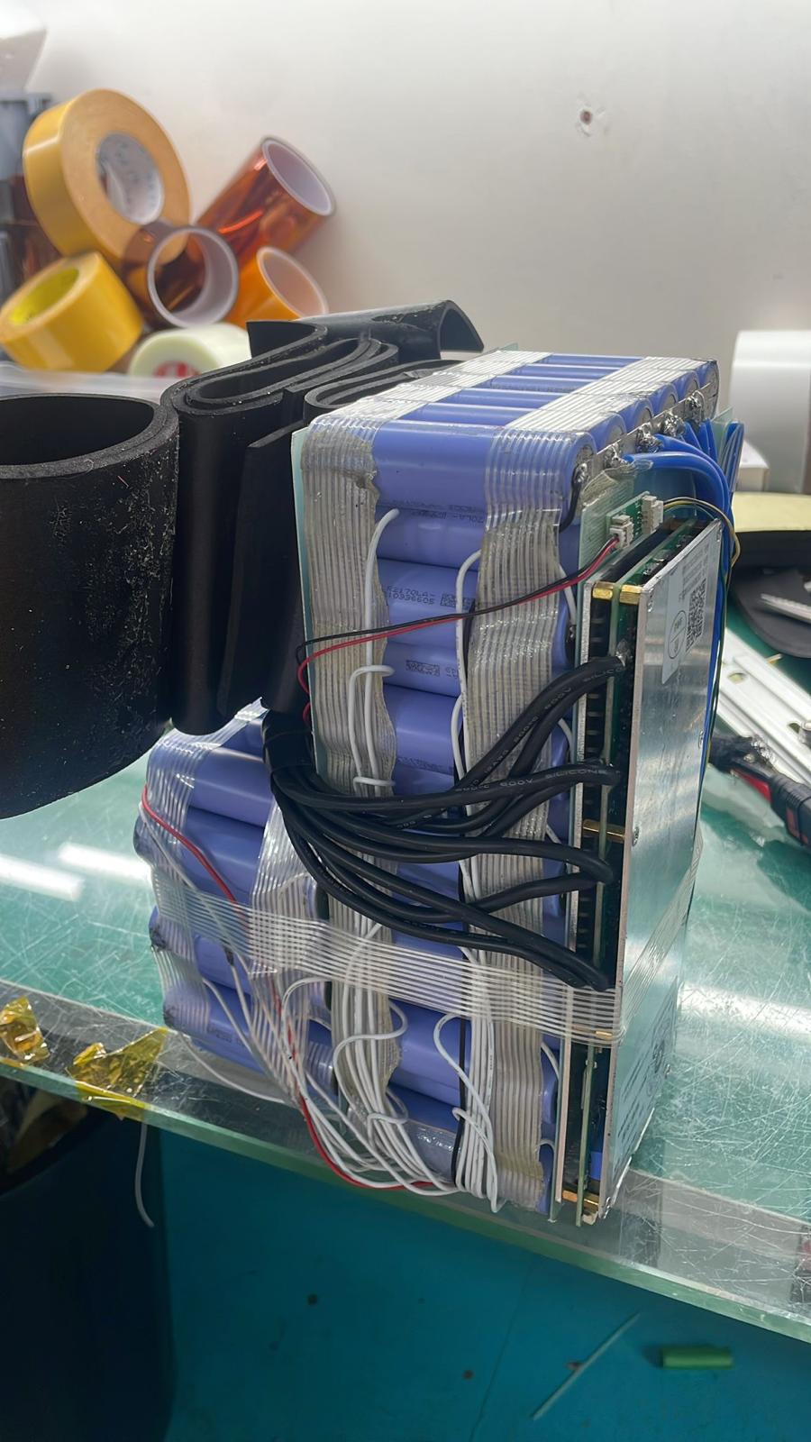 Opened second-hand lithium battery with exposed BMS and loosely routed wiring