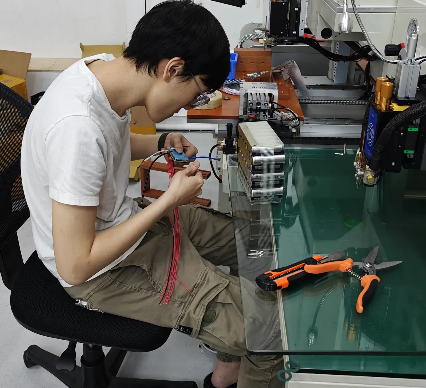 A DogeTune builder connecting battery-management wiring at the workbench